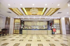 A hotel reception area with a marble floor, a reception desk, and a chandelier. - Jialida Hotel (Guangzhou)