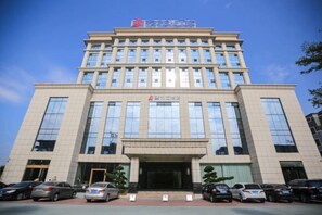 A multi-story building with a large entrance and several cars parked in front. - Jialida Hotel (Guangzhou)