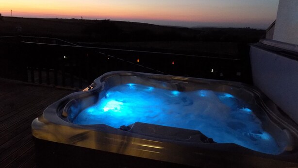 A hot tub on a wooden deck with a sunset view. - Brookfield (Bude)