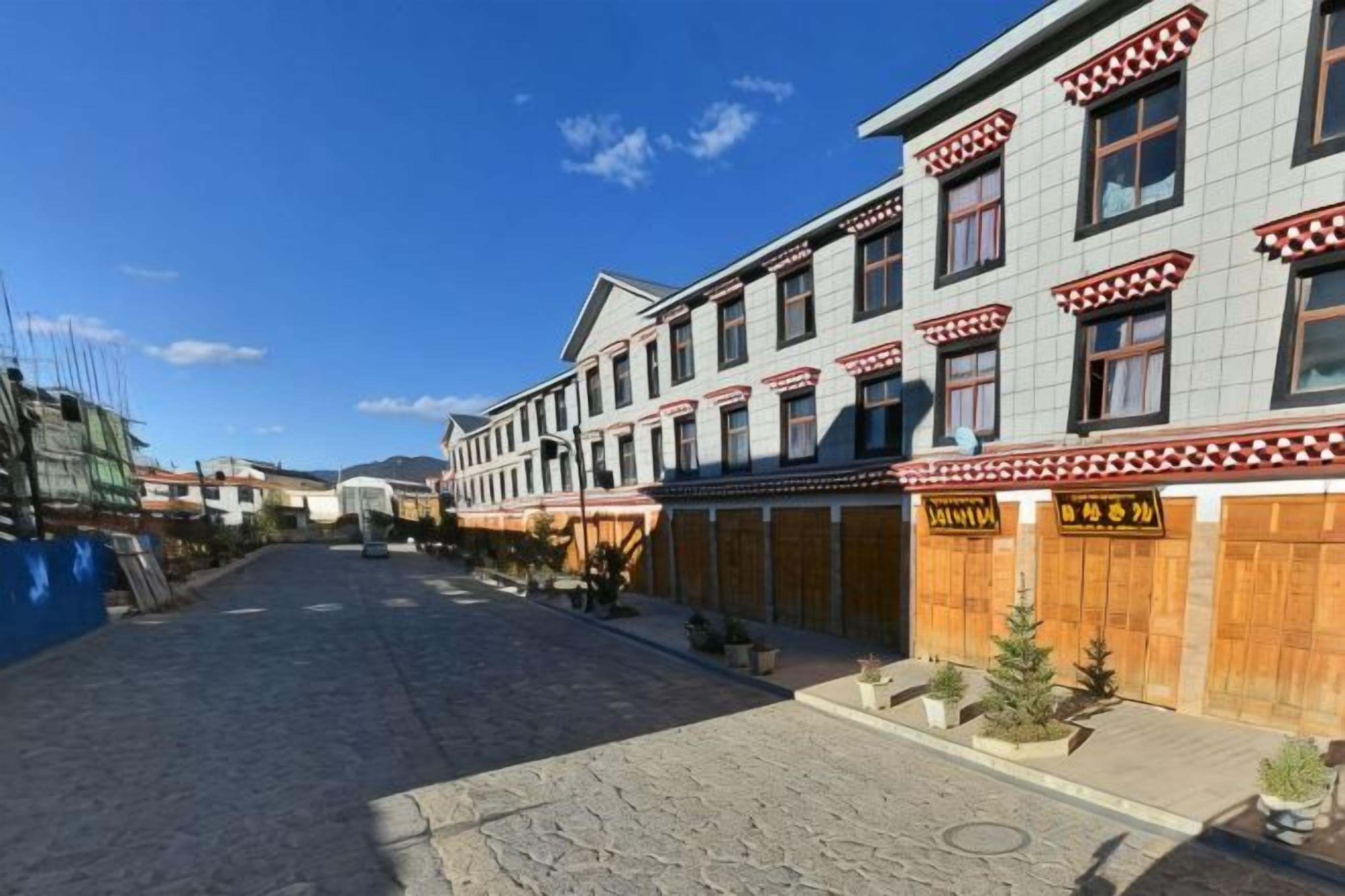 A street with buildings, some with signs, and a clear sky.