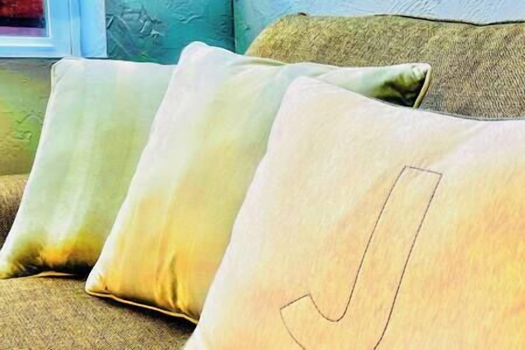 A row of four pillows with a gradient color scheme on a couch.