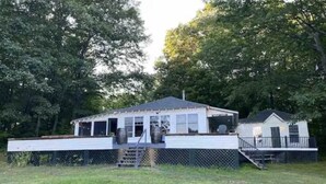 A single-story house with a porch, a fenced yard, and a small deck. - Hilltop Cottage (Argyle)