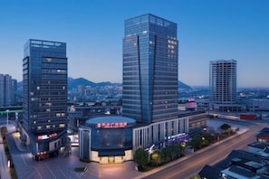 A modern hotel with a glass facade, multiple floors, and a prominent entrance. - Oriental Plaza Hotel (Changshan)