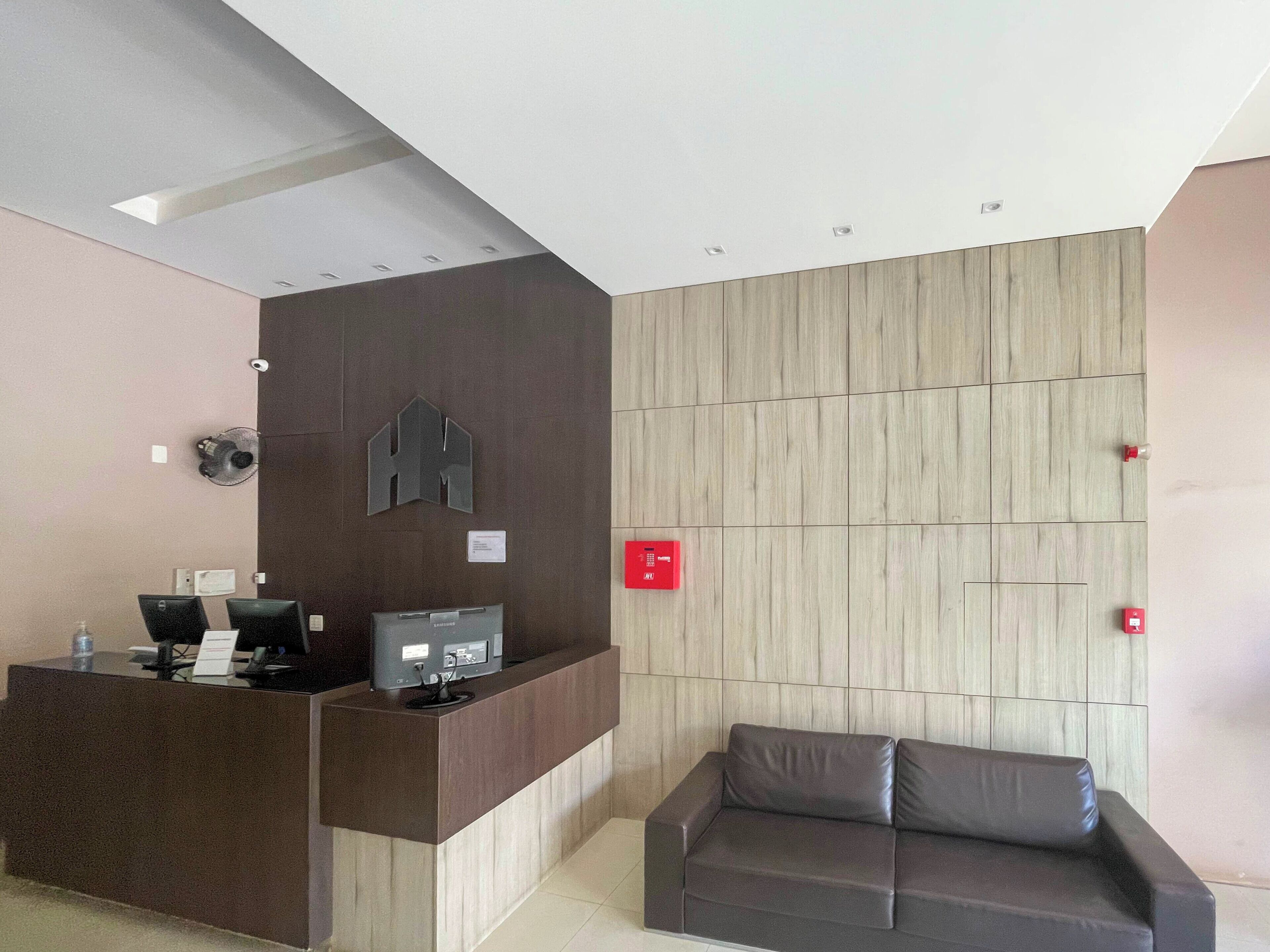 A reception area with a desk, computer, and a couch.