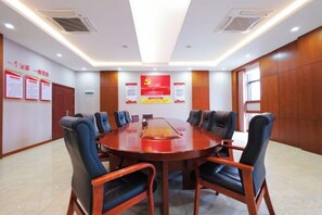 A conference room with a round table, chairs, and informational posters on the walls.