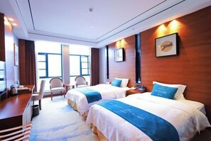 A hotel room with two beds, a desk, chairs, and a large window. - Huamei Hotel (Suijiang)