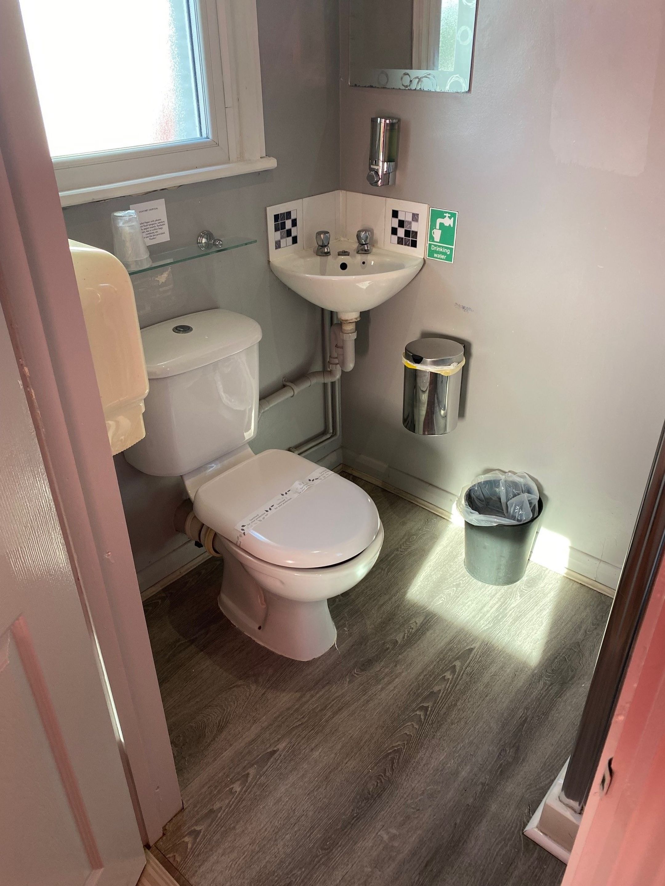 Une petite salle de bain comprenant des toilettes, un lavabo et une poubelle.