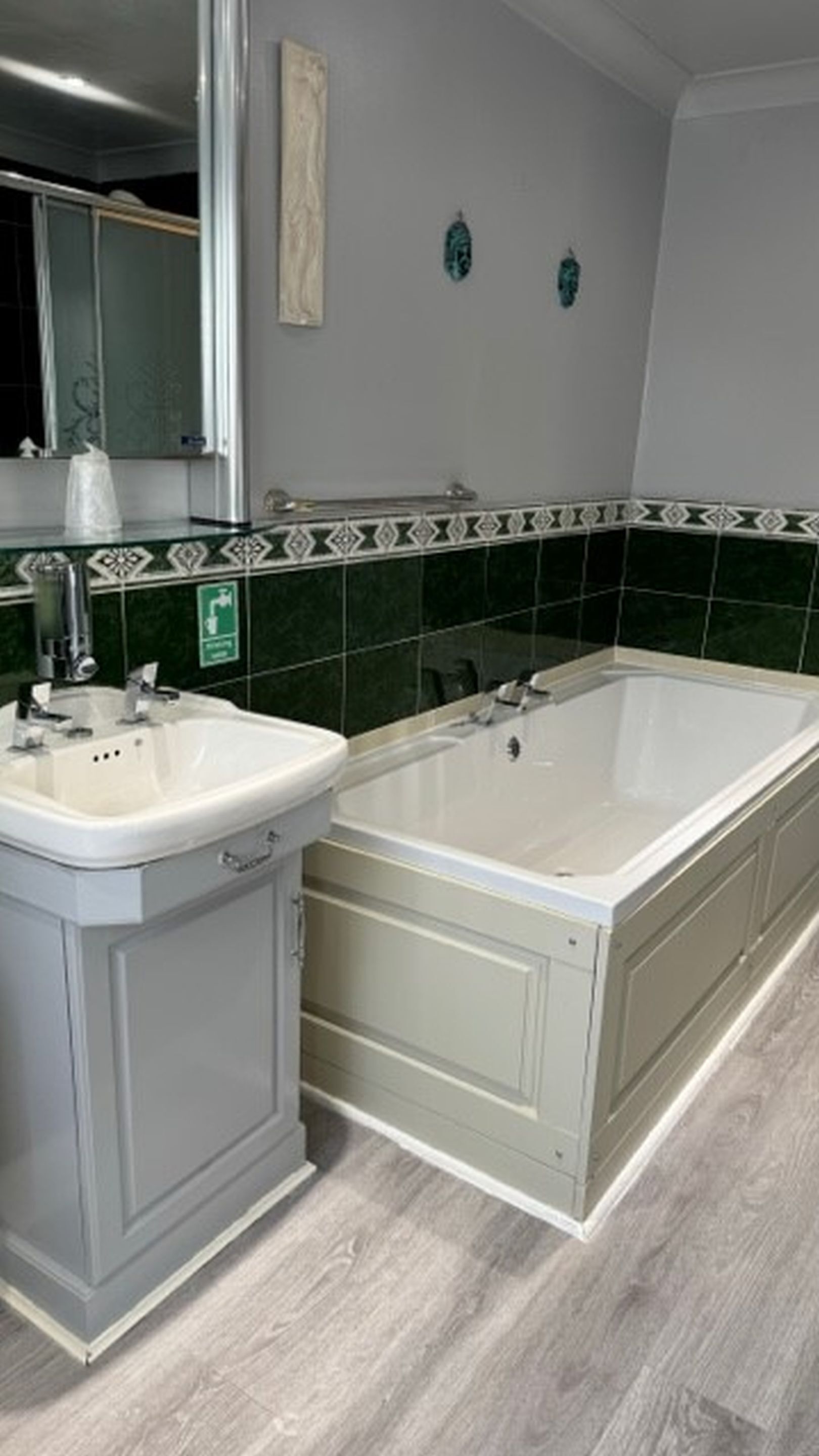 Une salle de bain avec un lavabo, un miroir et une baignoire.