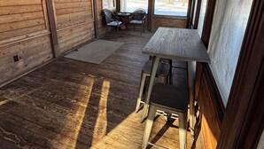 A wooden interior with a table and chairs, a ceiling fan, and large windows. - The Yellow Farm (Spring Green)