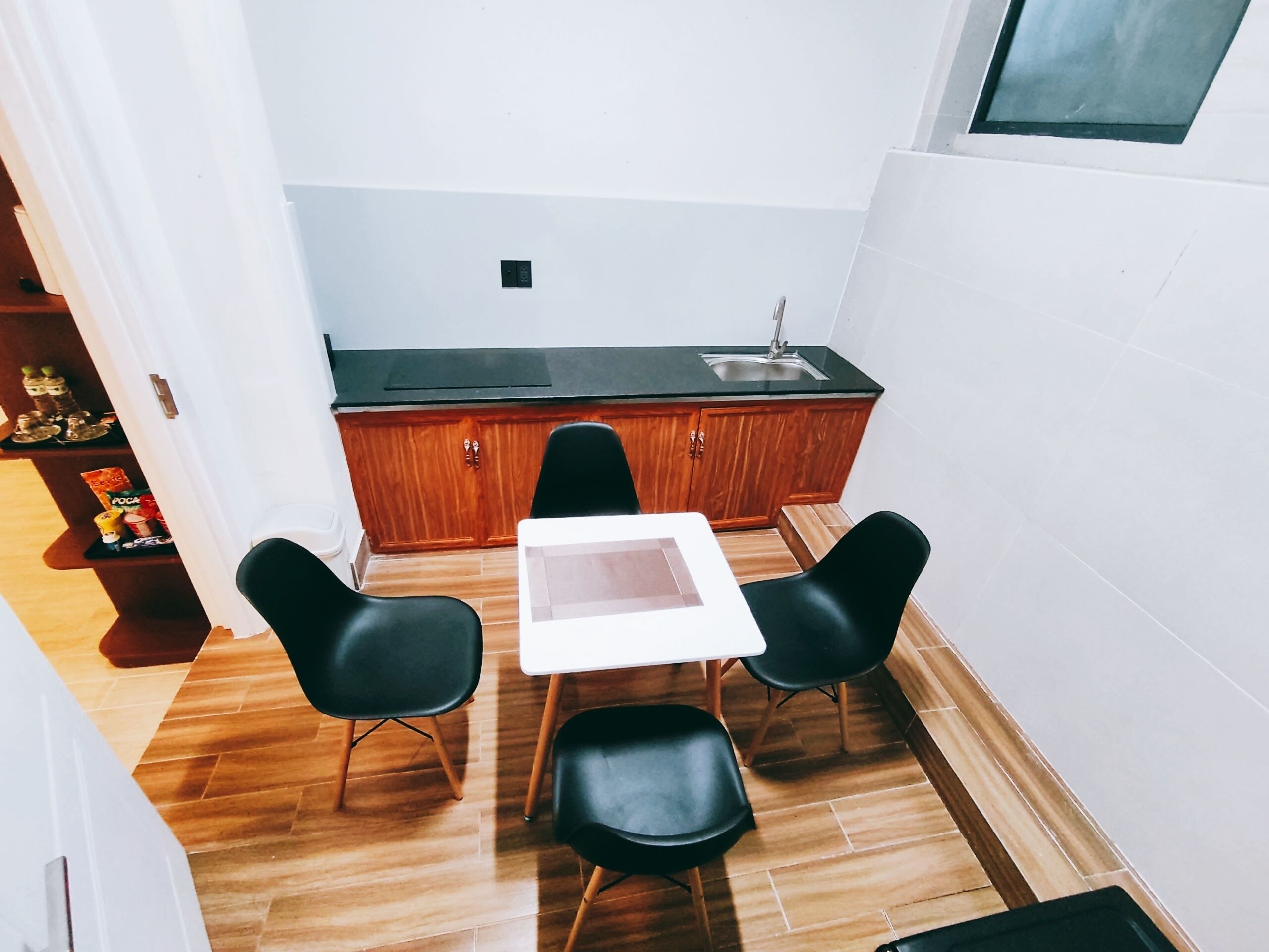A small kitchen with a table and chairs, wooden cabinets, and a window.