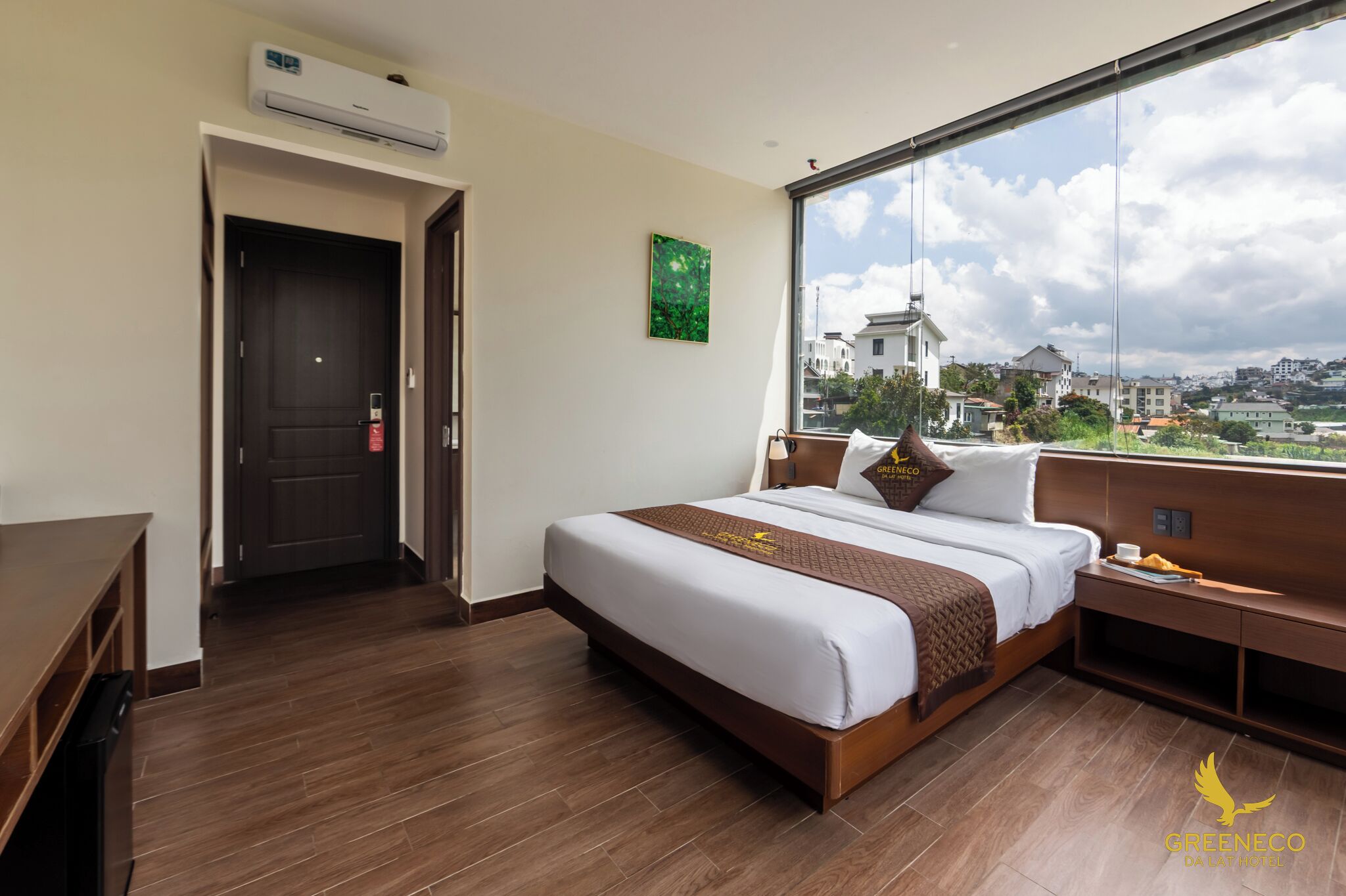 Une chambre d’hôtel avec un grand lit, un bureau et une vue sur la ville.