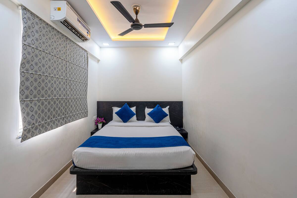 Une chambre à coucher moderne, équipée d’un lit, d’un ventilateur de plafond et d’un appareil de climatisation.