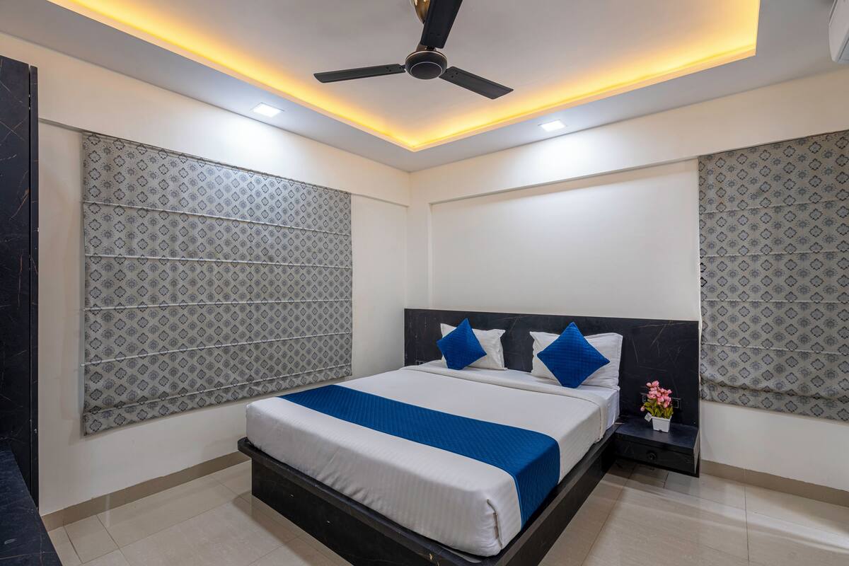 Une chambre à coucher moderne avec un lit, un ventilateur de plafond et des murs à motifs.