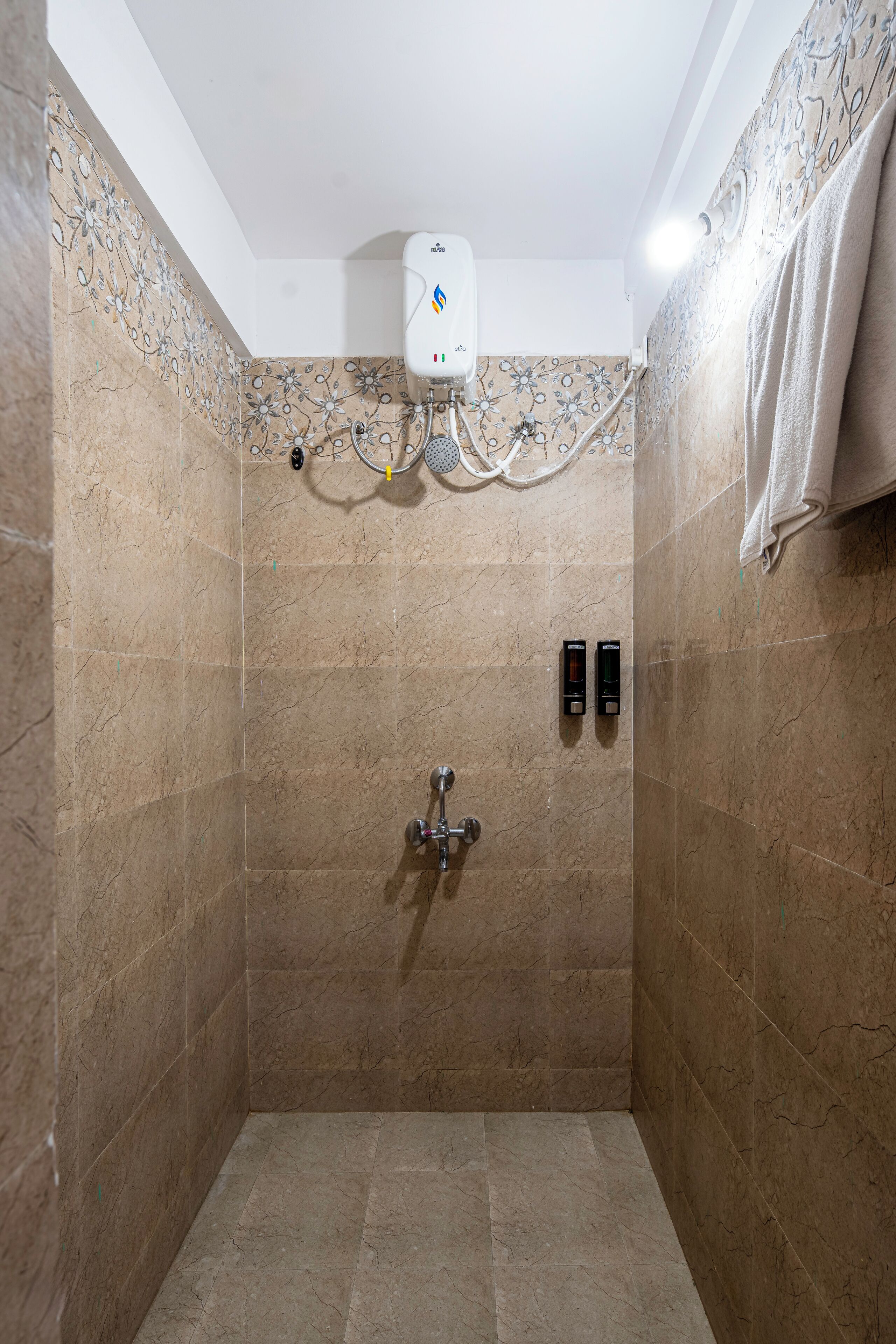 A shower with a control panel, a towel rack, and a water heater.