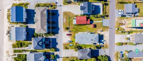 Vista aérea de una zona residencial con varias casas, calles y una playa.