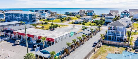 A coastal residential area with houses, a gas station, and a beach in the background.