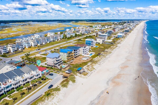 A coastal residential area with beachfront properties, including multi-story buildings and single-family homes, with a road running parallel to the beach. - The Bungalows F- Beachfront - Dog Friendly - Gazebo - Bikes (Surf City)