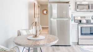 A modern kitchen with white cabinetry, a built-in oven, and a microwave. - The Hideaway B- Beach - Dog Friendly - Playground - Bikes - Fenced in Yard (Surf City)