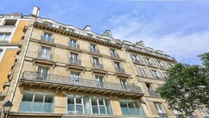 Un edificio de varios pisos con balcones, ventanas amplias y un estilo arquitectónico clásico.