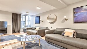 Una sala de estar moderna con un sofá, una mesa de centro y un televisor de pantalla plana.