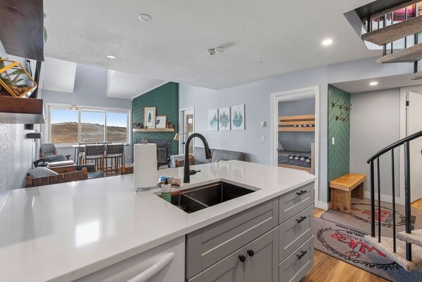 A modern kitchen with a large island, built-in appliances, and a view of the outdoors.