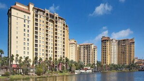 A high-rise hotel with multiple floors, a waterfront view, and a pool area. - 4 Bedroom Presidential Suite inside Disney Property @ Wyndham's Bonnet Creek (Lake Buena Vista)