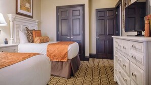 A hotel room with two beds, a dresser, a mirror, and a patterned floor. - 4 Bedroom Presidential Suite inside Disney Property @ Wyndham's Bonnet Creek (Lake Buena Vista)