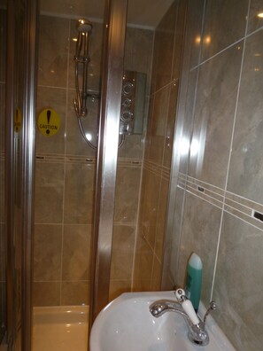 Een douche, handdoeken, zeep, toiletpapier