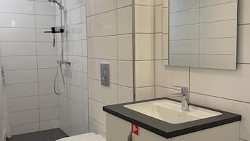 Un baño moderno con inodoro, lavabo y ducha.