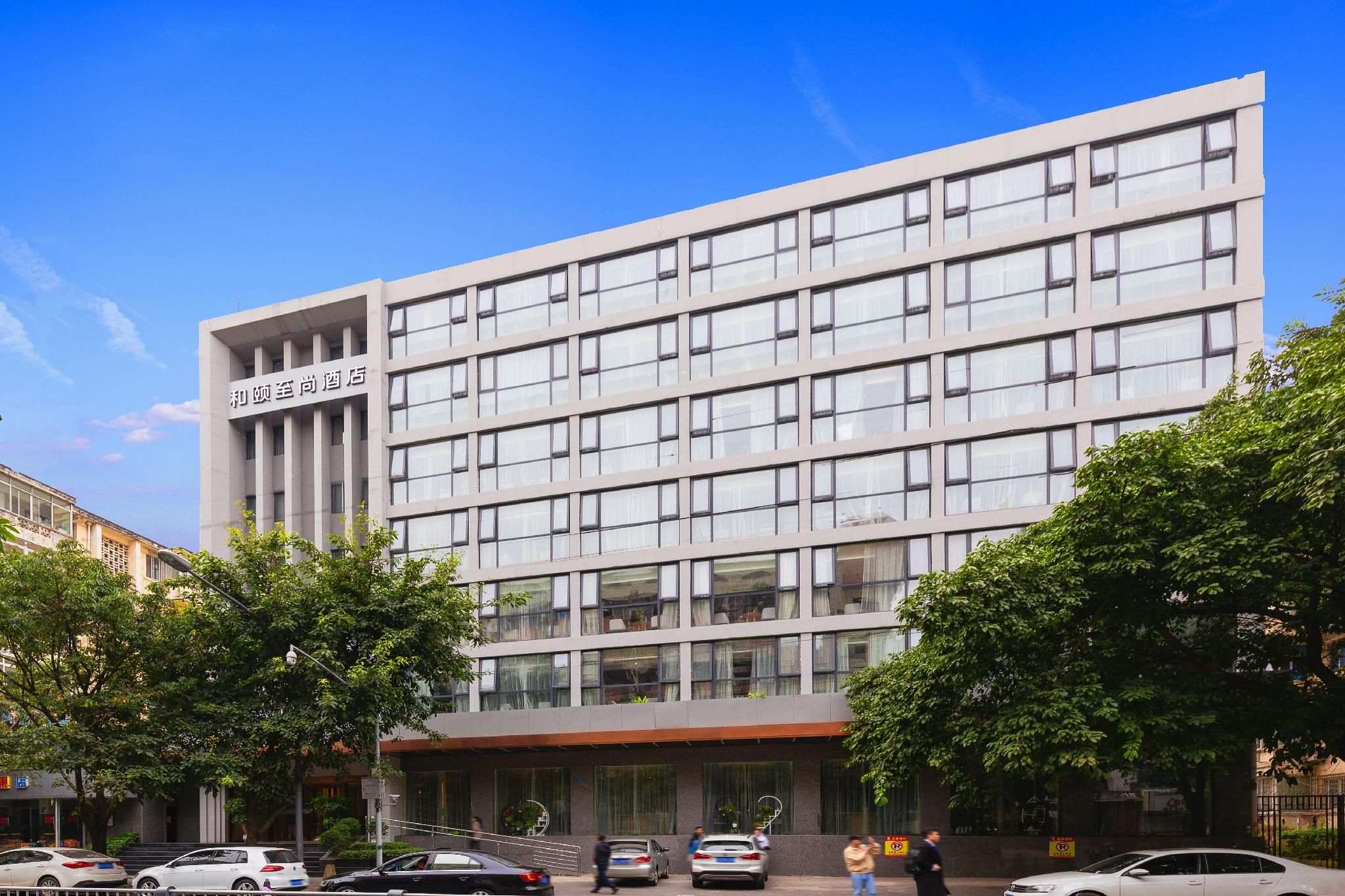 Un moderno edificio de hotel con fachada plana, amplias ventanas y una entrada visible.