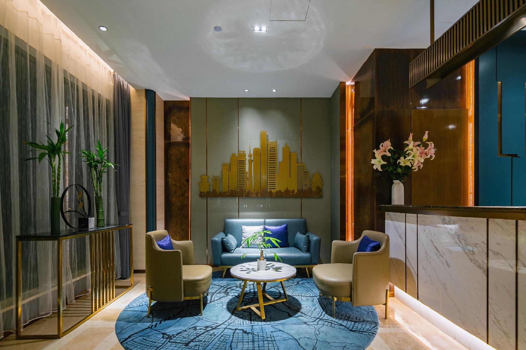 A modern interior with a blue patterned rug, a sofa, two armchairs, a round coffee table, and a cityscape wall art.