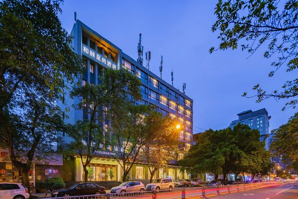 A hotel with a modern facade, multiple floors, and a prominent entrance.