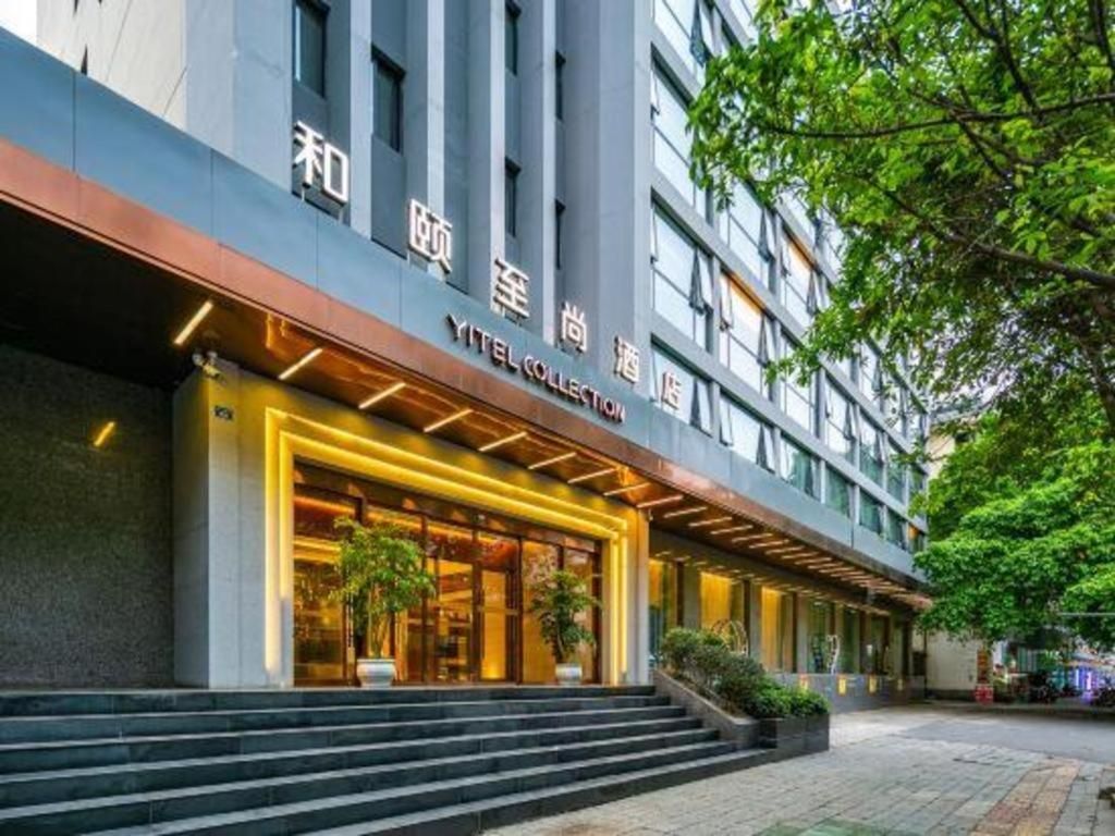 A hotel entrance with a modern facade, a visible staircase leading to the entrance, and a sign indicating the hotel name.