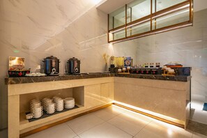 A modern kitchen with marble countertops, a built-in stove, and a variety of cooking utensils and appliances.