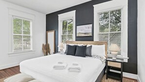 Una camera da letto con un letto grande, due comodini e vista all'esterno dalle finestre.