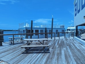 A wooden pier leading to a dock with a boat, benches, and a building with a large 'B' sign. - Bud N' Mary's Fishing Marina (Islamorada)