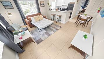 Un apartamento moderno con sala de estar, cocina, comedor y un balcón pequeño.