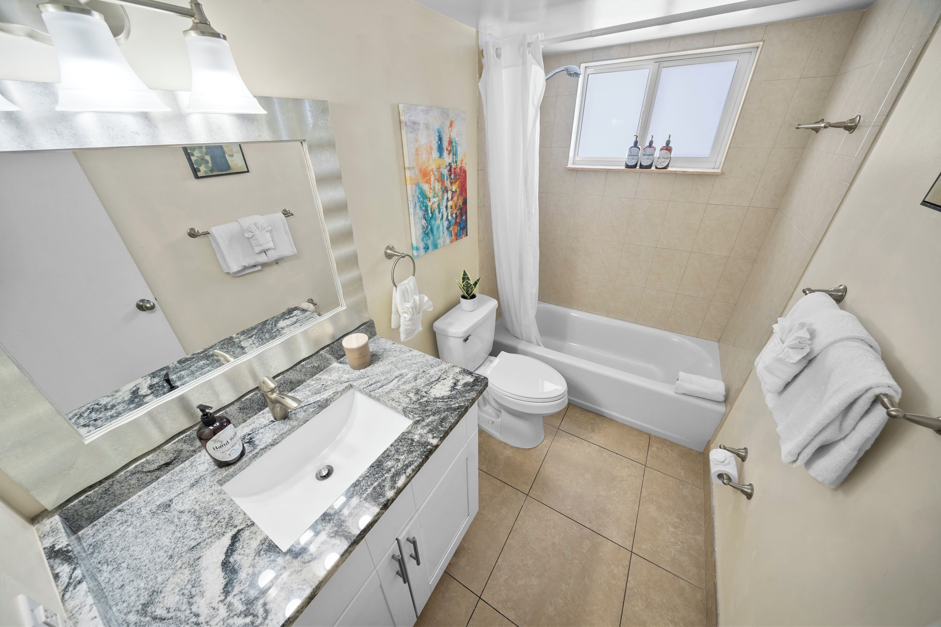 A bathroom with a sink, toilet, and bathtub.