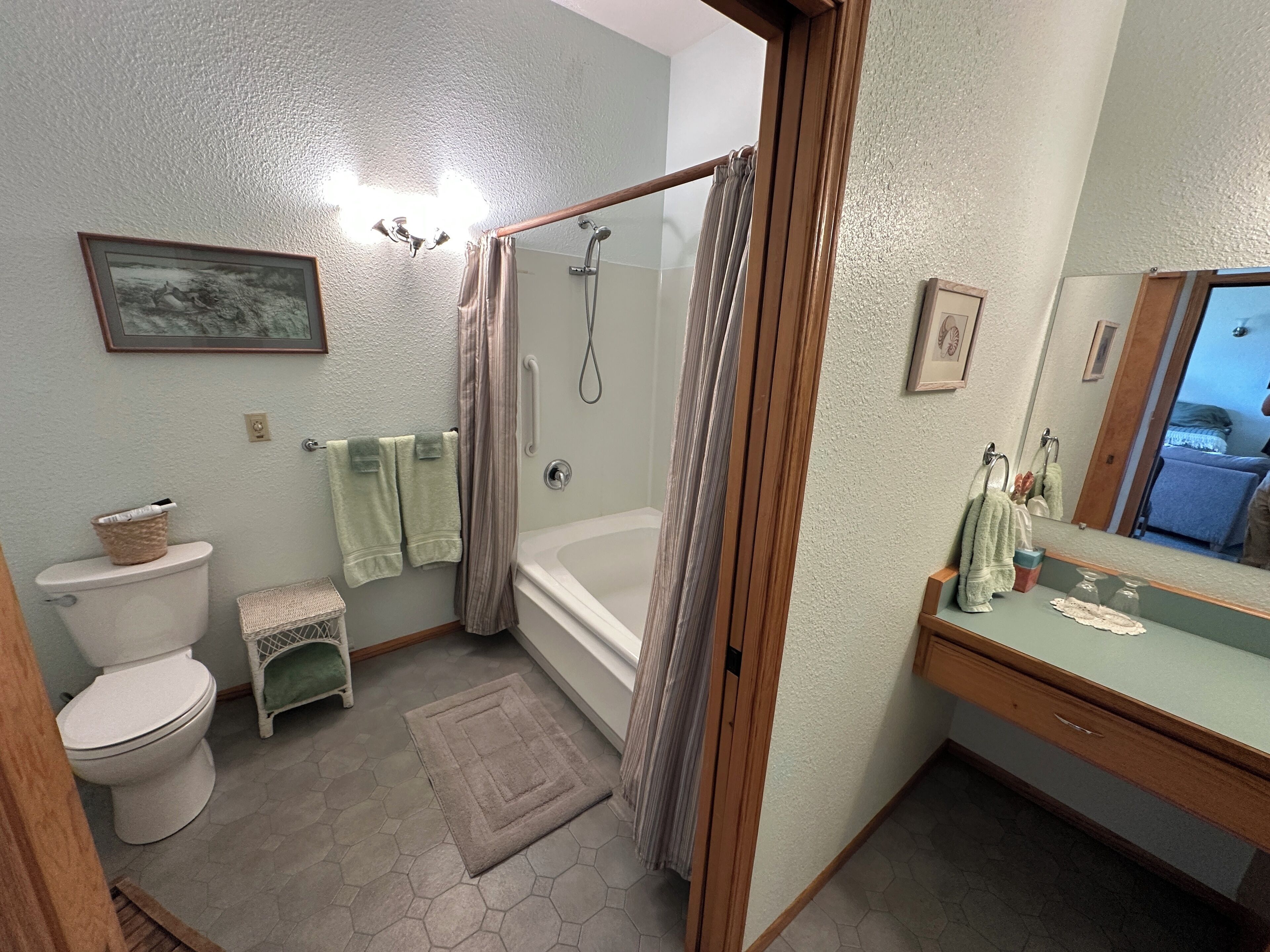 A bathroom with a shower, toilet, and sink.