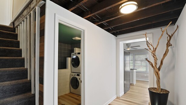 A modern apartment with a staircase, a laundry room, and a potted tree. - Fishermen's Catch (Frederica)