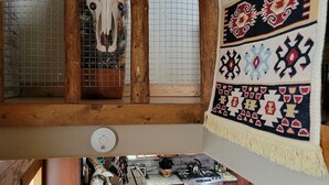 Eine rustikale Küche mit Holzbalken, einer gefliesten Spritzschutzwand und einem dekorativen Hängeelement.