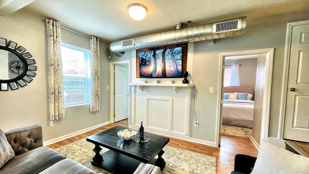 Una sala de estar con chimenea, televisor y comedor con mesa y sillas.