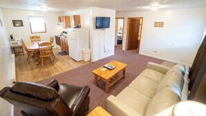 A compact living space with a dining area, kitchen, and a living room with a sofa and a coffee table. - Family Suite in Ohiopyle- Walk to Falls & Trails (Ohiopyle)