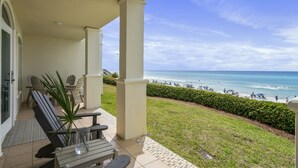 A covered patio with outdoor seating, a view of the beach, and a clear sky. - SPECTACULAR CONDO, GULF-FRONT, VIEWS, POOL, GRILL, LG. PATIO, PRIVATE BEACH (Santa Rosa Beach)