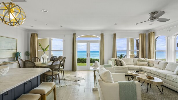 A spacious living room with a large window overlooking the ocean, a dining area with a view, and a modern ceiling fan. - SPECTACULAR CONDO, GULF-FRONT, VIEWS, POOL, GRILL, LG. PATIO, PRIVATE BEACH (Santa Rosa Beach)