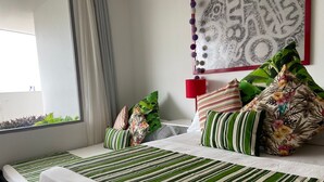 Une chambre d’hôtel avec un lit, une fenêtre et un mur orné d’un élément décoratif.