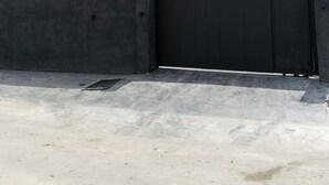 A modern multi-story building with a combination of white and dark grey exterior walls, large windows, and a gated entrance. - THE GRID RESIDENCE (Lagos)