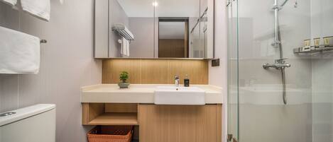 A modern bathroom with a toilet, sink, and shower.