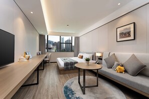Una habitación de hotel moderna con una cama grande, un sofá, un escritorio y una televisión.