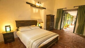 Un dormitorio con una cama de madera, una mesita de noche con lámpara y un armario de madera.